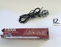 Sony F-500A microphone with attached cable and 1/4 inch plug alongside original maroon and white Sony box.
