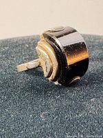 Close-up side angle of vintage Art Deco sterling silver and onyx ring showing the band and inset onyx stone with some tarnishing and wear.