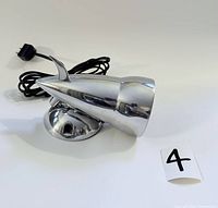 Side view of the nickel plated vintage IKEA Bor wall lamp with power cord and plug coiled beside it, showing the lamp's conical shape and base.