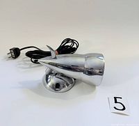 Full view of the vintage silver nickel-plated wall lamp with attached black electrical cord and plug, positioned beside a lot number tag '5'.