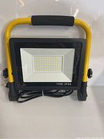 Front view of the 70W LED work light showing LED panel and yellow frame