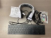 Overview of the wired keyboard, gaming headset, cables, and manual on surface