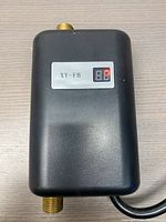 Front view of black housing showing XY-FB label, LED display and top brass fitting