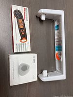 Digital meat thermometer in packaging, white storage rack, seen from above on a flat surface.