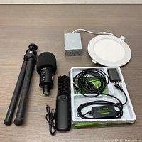 Full bundle display showing all items together: slim panel light with driver, coaxial to optical converter, hair straightener brush, microphone with windscreen, and tripod mount tripod.