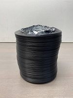 Side view of the coiled flexible dryer vent hose showing the black ribbed plastic exterior and the coiled structure.