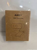 Front view of sealed Aukey 1080P Webcam box with product illustration and branding.