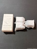 Set of 3 USB power adapters, one box with USB power adapter printed on it and three adapters individually wrapped in white plastic.