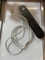 Full view of Fanlide power strip showing 6.5ft white power cord and black body with multiple outlets and ports.