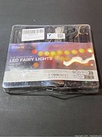Front view of LED fairy lights set in clear plastic packaging showing brand and lighting product display.