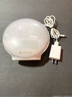Ecozy sunlight simulation alarm clock placed on a flat surface showing front dome-shaped design and brand logo.