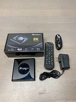 Full kit including box, TV box, remote, power adapter, and HDMI cable laid out on floor.