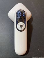 Handheld white cellulite massager with digital display and control buttons, in good condition.