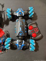 Top view of one blue and black remote-controlled car with blue multi-directional wheels, showing body design and wheel type.