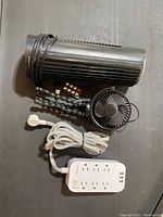 Fan bundle including a black wired tower fan with remote control, small black USB-powered fan, and white power strip with braided cable.