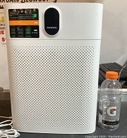 Full frontal view of the white Morento air purifier with power cable and adapter visible, showing clean condition and intact labels.