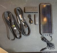 Image showing the USB power cable, remote control, 5-in-1 HDMI switch, solar panel with wired connector, and two power cords including power bar.