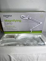 Photo of the boxed Bemelux magnifying lamp with packaging showing the product image and features