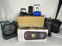 Overview of the lot including fans, boxed speaker, and Sleep Lux mattress topper.