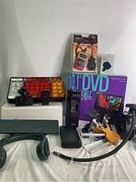 Full lot view showing dash cams, tail lights, code reader, DVD player box, dent removal kit, and accessories.