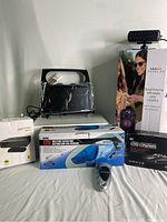 Grouped image of the lot showing boxed Bluetooth speaker with LED lights, blue 12V wet/dry vacuum, black dash cam box, digital tire gauge, a black radio/navigation device, and a black auto air purification heat fan.