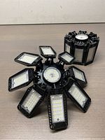 Two LED garage lights shown from front and side angles, displaying multiple small LED arrays on each adjustable panel.