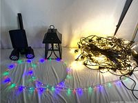 Photo showing all items in the lot: two solar spotlights, lantern, LED strip, and string lights.