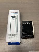 Photo of the original packaging for U8 Cabinet Light and Electeck wall socket, showing product names and new condition.