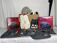 Full view of travel and audio bundle showing two Panasonic CD boomboxes in boxes, black and orange packing organizers, white sandals and black flip flops, neck pillow, adapters, and other travel accessories.