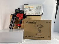 Photo shows WorkPro brad nailer in red and black, AvidPower 20V cordless inflator box, 22-outlet power strip box, and dual water timer behind.