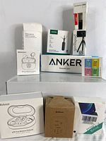 Photo showing the full lot including multiple wireless earbuds boxes, Bluetooth speaker box, Joby GorillaPod box, and charging accessories.
