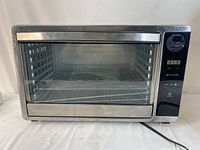 Front view of stainless steel food dehydrator with glass door and digital control panel.