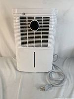 Front view of white Hogarlabs dehumidifier showing front grill and circular knob with power cord visible
