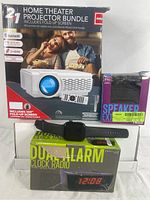 Box and items displayed: home theatre projector bundle box, Bluetooth wireless speaker box, smart watch, and dual alarm clock radio box