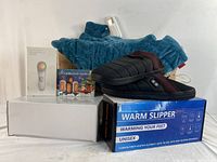 Overview of heating pad, heated slippers on box, two hand warmer boxes, and optical rejuvenation device box on table