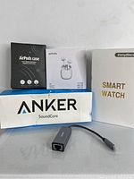 Bundle items boxed: AirPods case, Yobola T9 wireless earbuds box, Anker SoundCore Bluetooth speaker box, EarlySince smart watch box, USB-C to Ethernet adapter.