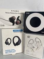 Photo showing boxes of three products: Kaugic noise reduction earplugs, Loop branded box, and black wireless sports earbuds box with sweatproof claim.