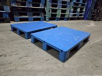 Two blue plastic pallet risers front view
