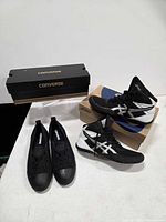 Converse and ASICS shoes displayed with their boxes