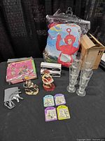 Group shot showing costume, glasses, staplers, charger cable set, shower curtain, magnets, and two figurines