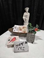 group shot of all items including serving set box, ceramic bowl, figurine, plaque, note cards, faux rose