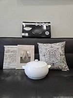 All five items grouped: boxed crepe maker, sealed tablecloth and fabric, pillow, Lagostina casserole