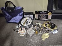 All items laid out: pressed glass bowl, purple tote, plates, banner, swirl decorations, tags, mini figure