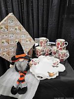 Entire lot: boxed mugs, platter packaging, Halloween gnome displayed together