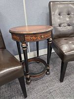 Full view of Bombay & Co round side table between two chairs