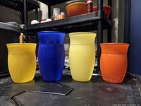 Front view of all four colored ribbed glass tumblers