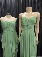 Two sage green strapless dresses displayed on mannequins front view