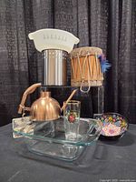 All seven items grouped: drum, Fire-King casserole, dip bowl, Pyrex dish, utensil holder, copper watering can, German beer glass