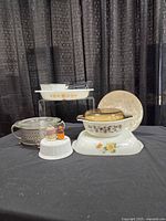 Full lot frontal view showing primary bakeware, cradle, enamel pot, charger, figurines