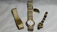 Three gold tone women's watches arranged side by side showing the watch faces and bands.